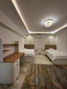 una camera con due letti e un lampadario a braccio di Al Sawah Stand Alone Villa With Private Pool a Sheikh Zayed
