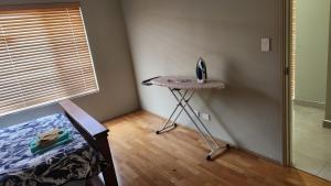 Beeliar Shared Home Stay في Coogee: غرفة نوم مع طاولة وسرير ونافذة