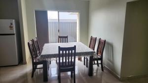Beeliar Shared Home Stay في Coogee: غرفة طعام مع طاولة وكراسي ومطبخ
