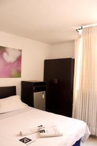 a bedroom with a bed and a black cabinet at Hotel Bucaramanga Plaza in Bucaramanga +51 photos