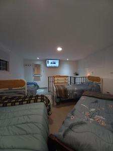 een woonkamer met 3 bedden en een flatscreen-tv bij Dúplex GUMANS in Goya