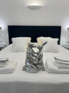a silver statue of a rabbit sitting on a bed at The White Knight Premium Boutique Hotel in Għajnsielem