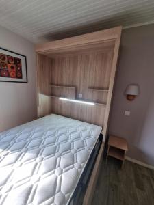 une chambre avec un grand lit et une lampe dans l'établissement VVF Cantal Champs-sur-Tarentaine, à Champs Sur Tarentaine
