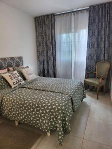 a bedroom with a bed and a chair and a window at Cosy 2 bedroom near sea Costa del Silencio in Costa Del Silencio