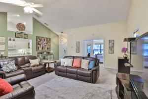 sala de estar con muebles de cuero y TV en Cypress Lake - Pool Home, en Sarasota