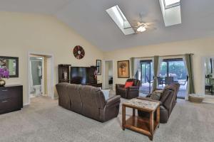 sala de estar con muebles de cuero y TV en Cypress Lake - Pool Home, en Sarasota