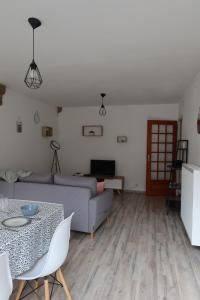 een woonkamer met een bank en een tafel bij * La Tour : Vue imprenable sur la ville * in Luxeuil-les-Bains