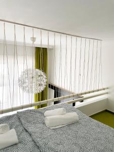 ein Schlafzimmer mit zwei weißen Handtüchern auf einem Bett in der Unterkunft Deluxe Cosmopolitan Apartment Budapest, with Private Parking in Budapest