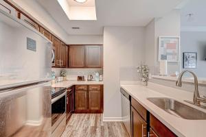 una cucina con armadi in legno e lavandino di Amazing Houston Apartment with Pool+ Fast Internet a Houston