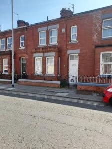 un edificio de ladrillo rojo al lado de una calle en Large house sleeps13 close to lfc stadium anfield, en Liverpool