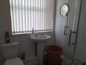 baño con lavabo y aseo y ventana en Large house sleeps13 close to lfc stadium anfield, en Liverpool