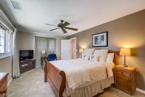 1 dormitorio con 1 cama y ventilador de techo en Coastal Sol, en Sarasota