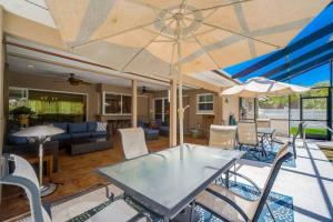 un patio con mesa, sillas y sombrilla en Coastal Sol, en Sarasota