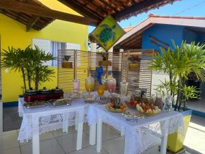 a white table with fruits and drinks on it at Pousada Tio San in Japaratinga