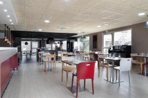 une salle à manger avec des tables et des chaises dans un restaurant dans l'établissement Campanile Créteil - Bonneuil Sur Marne, à Bonneuil-sur-Marne