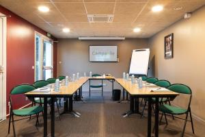une salle de conférence avec une grande table et des chaises vertes dans l'établissement Campanile Créteil - Bonneuil Sur Marne, à Bonneuil-sur-Marne
