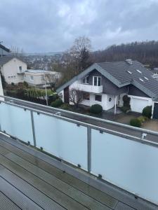 einen Balkon mit Blick auf ein Haus in der Unterkunft FewoLINDE OG in Olpe