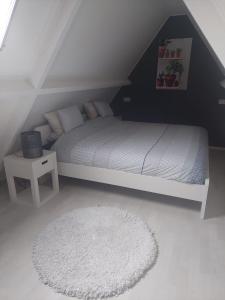 a bedroom with a white bed and a white rug at B&B de Waander 
