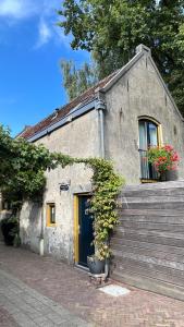 un piccolo edificio in pietra con porta e finestre blu di Het Suikerpandje a Gouda