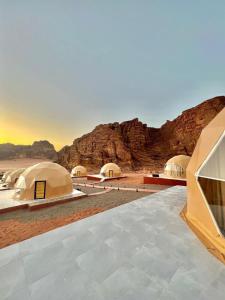 a group of tents in the desert with mountains at Flower Life Camp in Wadi Rum