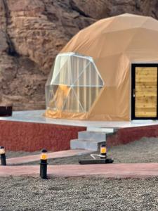 a large dome tent with stairs in front of a mountain at Flower Life Camp in Wadi Rum