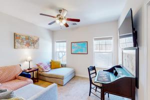 a living room with a couch and a ceiling fan at The Geography House in Montgomery