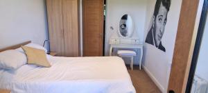 a bedroom with a white bed and a mirror at Relaxing Room With Ensuite Rutland Point in Morcott