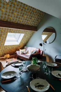 uma sala de jantar com uma mesa e um sofá em L’écrin vintage - Hors Château & Marches de Bueren em Liège