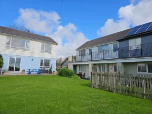 a house with a yard next to a fence at Bude Bolthole in Poughill