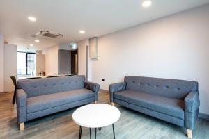 a living room with two blue couches and a table at Coleman Court Summer Apartments in Cork