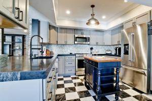 a kitchen with white cabinets and a checkered floor at Villa Manteago in Bradenton