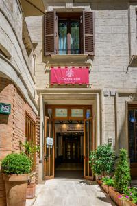 ローマにあるカーザ Ⅰ カプチーニのピンクの看板が貼られた建物の入口