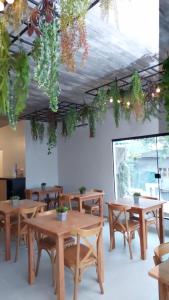 una stanza con tavoli in legno e piante appese al soffitto di Pousada Gaucha a Fernando de Noronha