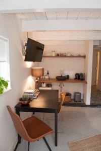 een bureau en stoelen in een kamer met een tv bij Het Suikerpandje in Gouda