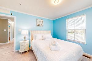 niebieska sypialnia z białym łóżkiem i oknem w obiekcie The Degohs w mieście White Plains