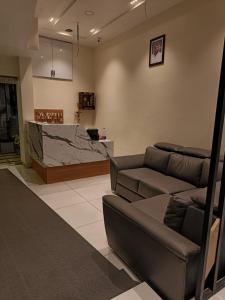 ein Wohnzimmer mit einem Sofa und einer Theke in der Unterkunft SREENARAYANA TOURIST HOME in Guruvāyūr
