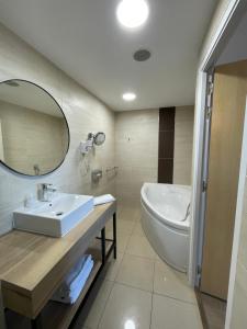 y baño con lavabo, bañera y espejo. en Campanile Montpellier Ouest - Croix D'Argent, en Montpellier