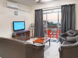 a living room with a couch and a flat screen tv at Colobeentoi Three Bedroom Sea View in Port Dickson