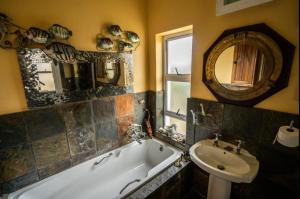 ein Badezimmer mit einer Badewanne, einem Waschbecken und einem Spiegel in der Unterkunft Royal Alfred Marina in Port Alfred