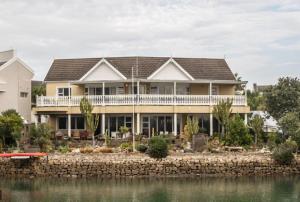 una casa grande con una gran terraza sobre el agua en Royal Alfred Marina, en Port Alfred