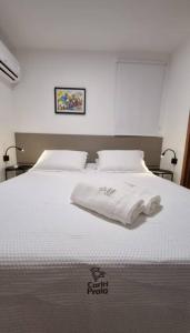 Una cama blanca con dos toallas encima. en Cobertura Vista Mar Carapibus - Cariri Praia - Apartamento completo com 02 quartos, en Conde