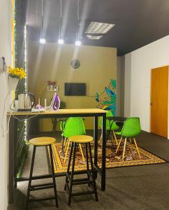 un bureau avec une table et des tabourets verts dans l'établissement AK Greenrise Meru, à Ipoh