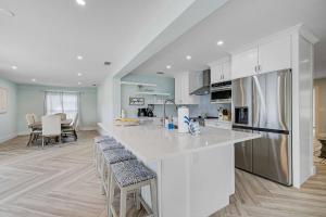 ブレーデントンにあるTranquil Breezeの白いキャビネット付きのキッチン、バースツール付きのキッチンアイランド