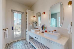a bathroom with two sinks and a large mirror at SBSL706 Luxury, Ocean front beach house, Hot Tub, Boardwalk to Beach in Port Aransas