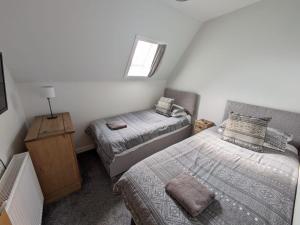 a small bedroom with two beds and a window at 2 Bedroom Townhouse on NC500, Wick, Highland in Wick