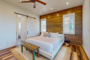 a bedroom with a bed and a wooden wall at SBSL706 Luxury, Ocean front beach house, Hot Tub, Boardwalk to Beach in Port Aransas