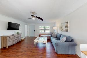 uma sala de estar com um sofá e uma televisão em Lounging Palms Estate em Fort Myers
