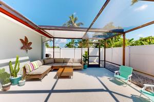 un patio al aire libre con sofá y sillas en Lounging Palms Estate, en Fort Myers