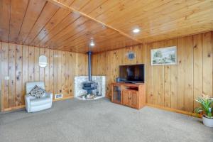 un soggiorno con camino e TV in una parete di legno di Hilltop Hideout with Sweeping Birch Bay Views a Blaine