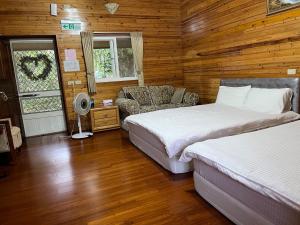 a bedroom with two beds and a living room with a couch at Yun Hsiang Zhan Chalet in Hualing